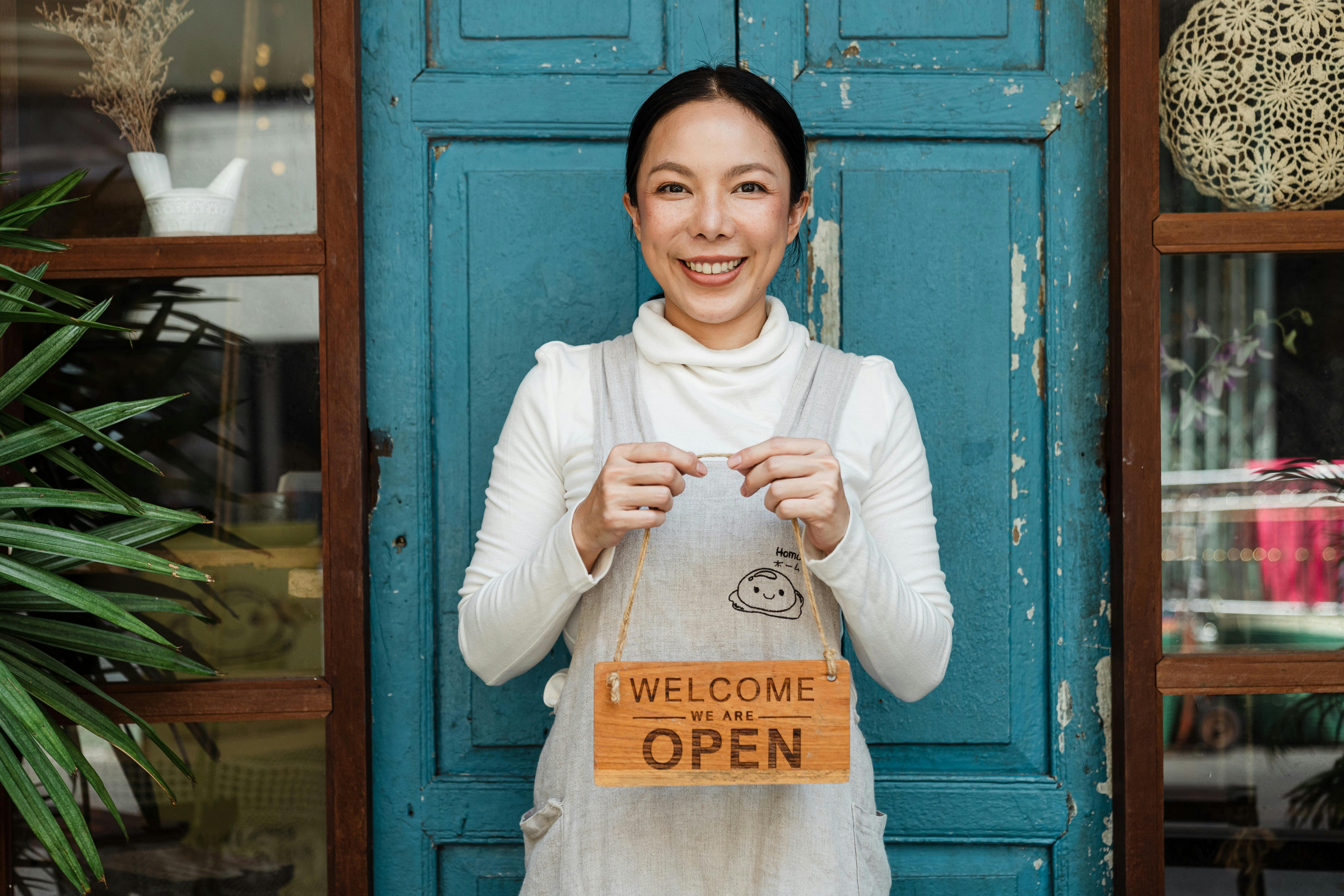 Business owner holding open sign